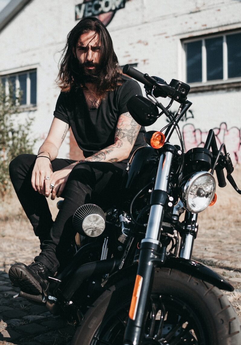 man sitting on black cruiser motorcycle