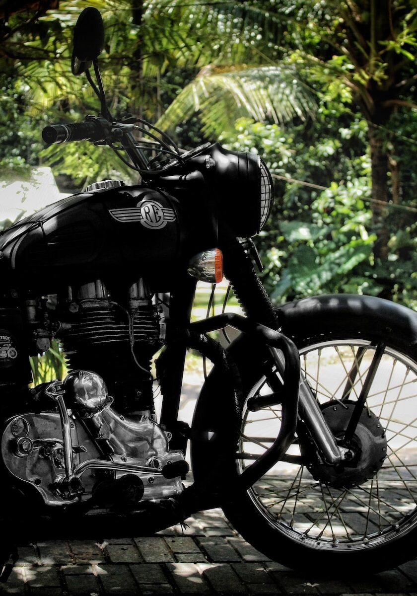 a black motorcycle parked on a brick road
